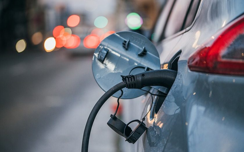 Detalhe de carro elétrico a ser carregado através do depósito de combustível