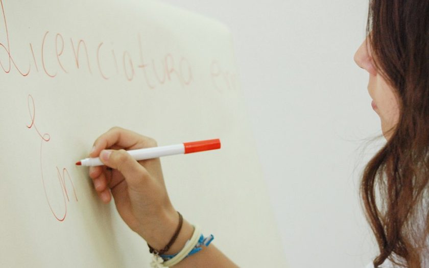 aluna a escrever num quadro branco com marcador