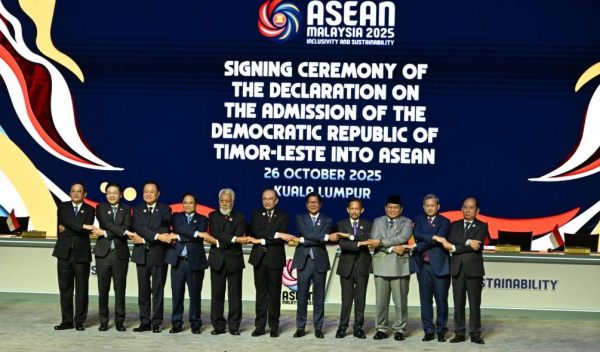 líderes da declaração de mãos dadas num palco oficial na declaração de entrada de Timor Leste