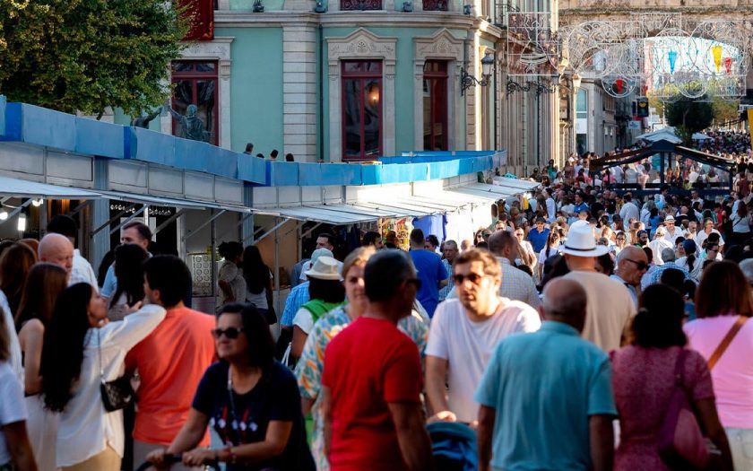 imagem de rua cheia de pessoas durantes as festas