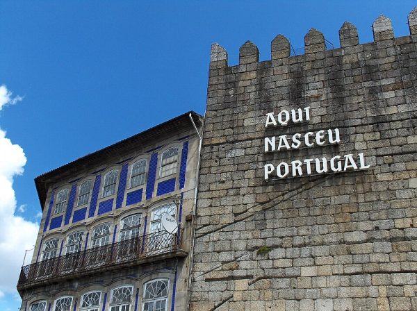 casa e torre com legenda "aqui nasceu portugal"