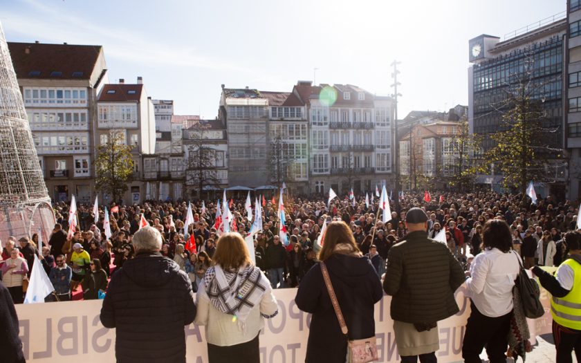 multidão de manifestantes num largo da cidade em dia ensolarado