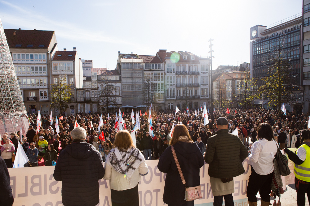 multidão de manifestantes num largo da cidade em dia ensolarado