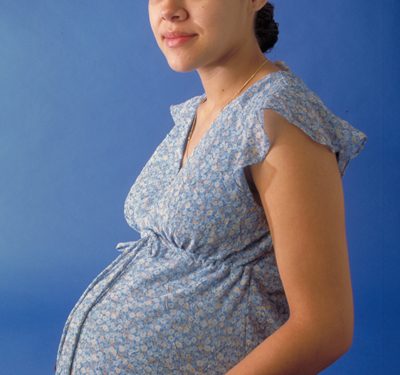 imagem de barriga duma grávida com vestido de flores azul