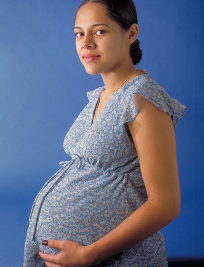 imagem de barriga duma grávida com vestido de flores azul
