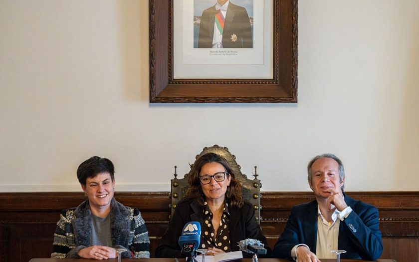 os presidentes da câmara sentados com a fotografia do PR Marcelo num quadro por trás