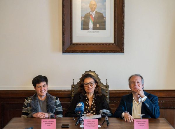 os presidentes da câmara sentados com a fotografia do PR Marcelo num quadro por trás