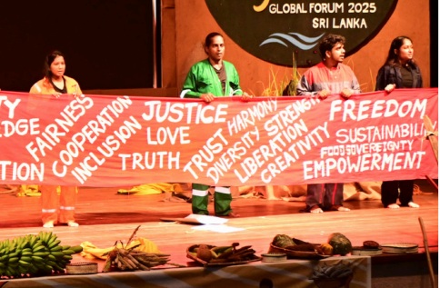 pessoas no palco a segurar uma faixa com palavras de ordem de justiça social