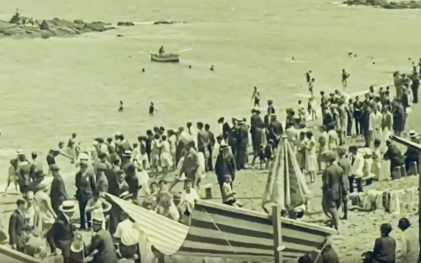 fotograma do filme em que se veem pessoas na praia de Riaçor na Corunha, vestidos com fatos da época