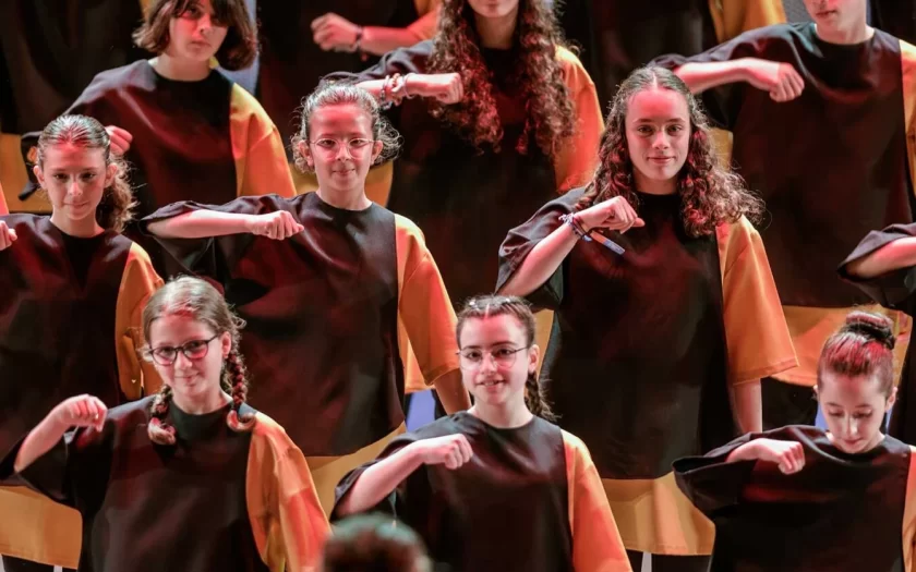 imagem do espetáculo com crianças vestidas de preto e amarelo a atuar