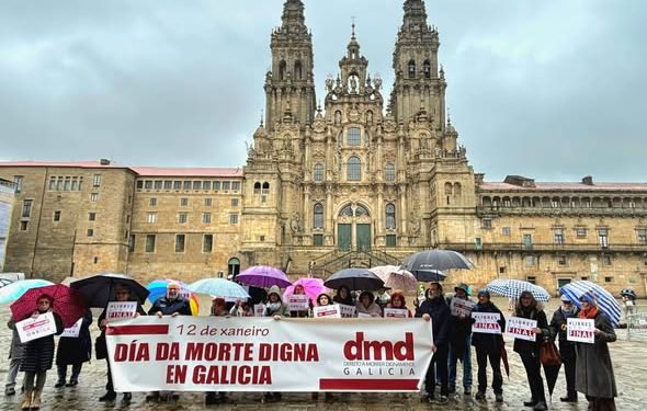pessoas a segurarrem uma faixa de protesto sobre o assunto diante da Catedral