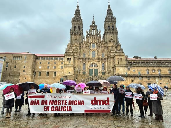 pessoas a segurarrem uma faixa de protesto sobre o assunto diante da Catedral