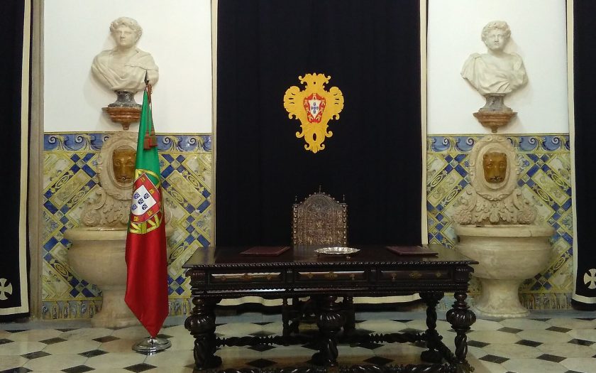Sala das Bicas do Palácio de belém com a mesa vazia e bandeira portuguesa ao lado