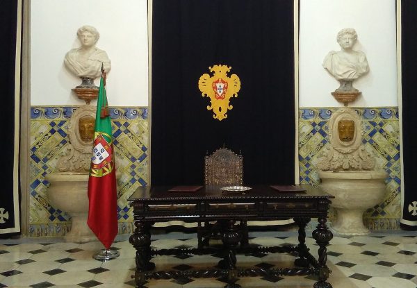 Sala das Bicas do Palácio de belém com a mesa vazia e bandeira portuguesa ao lado
