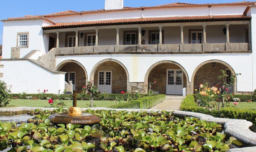 Pátio interior da Biblioteca de Cerveira, com a fonte de pedra no meio num dia ensolarado