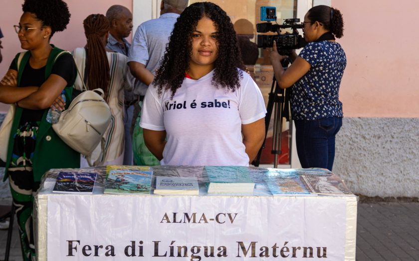 Jovem mulher com t-shirt branca com texto "Kriol é sabe"