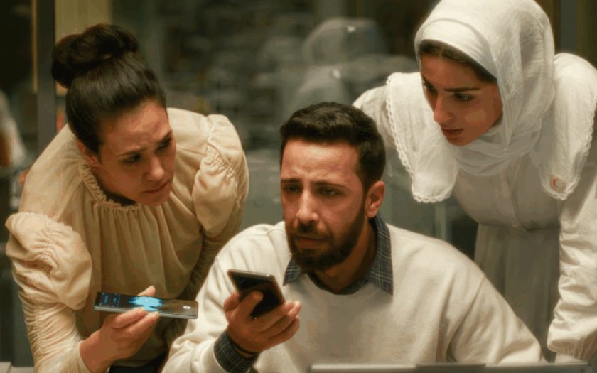 duas mulheres palestinianas e um homem muito preocupados atentos ao que se ouve nos telefone na mão de dois deles