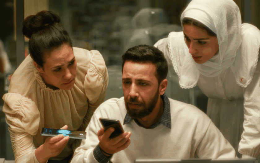 duas mulheres palestinianas e um homem muito preocupados atentos ao que se ouve nos telefone na mão de dois deles