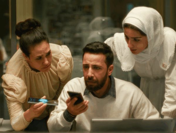 duas mulheres palestinianas e um homem muito preocupados atentos ao que se ouve nos telefone na mão de dois deles
