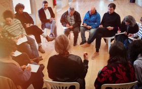 imagem de pessoas em roda a debater e tomar notas