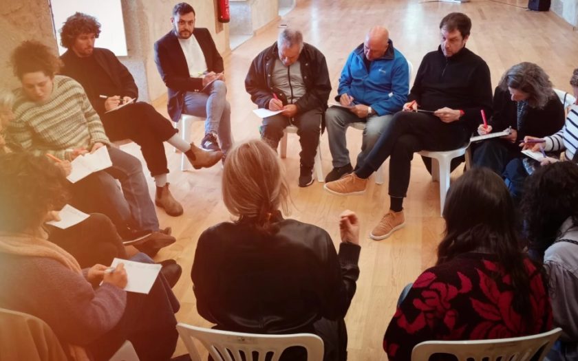 imagem de pessoas em roda a debater e tomar notas