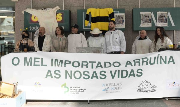 pessoas por trás duma faixa com legenda "O mel importado arruína as nossas vidas"