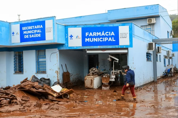 imagem de rua cheia de lama na entrada duma farmácia municipal no brasil