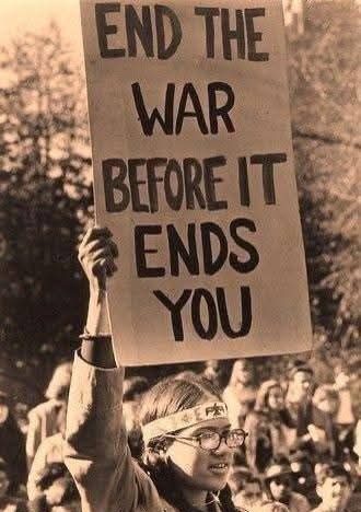 jovem a segurar um cartaz "end the war before it ends you"