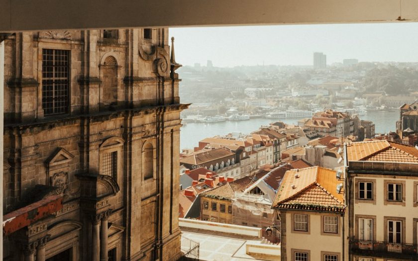 janela duma casa aberta para paisagem do Porto com o rio Douro ao fundo
